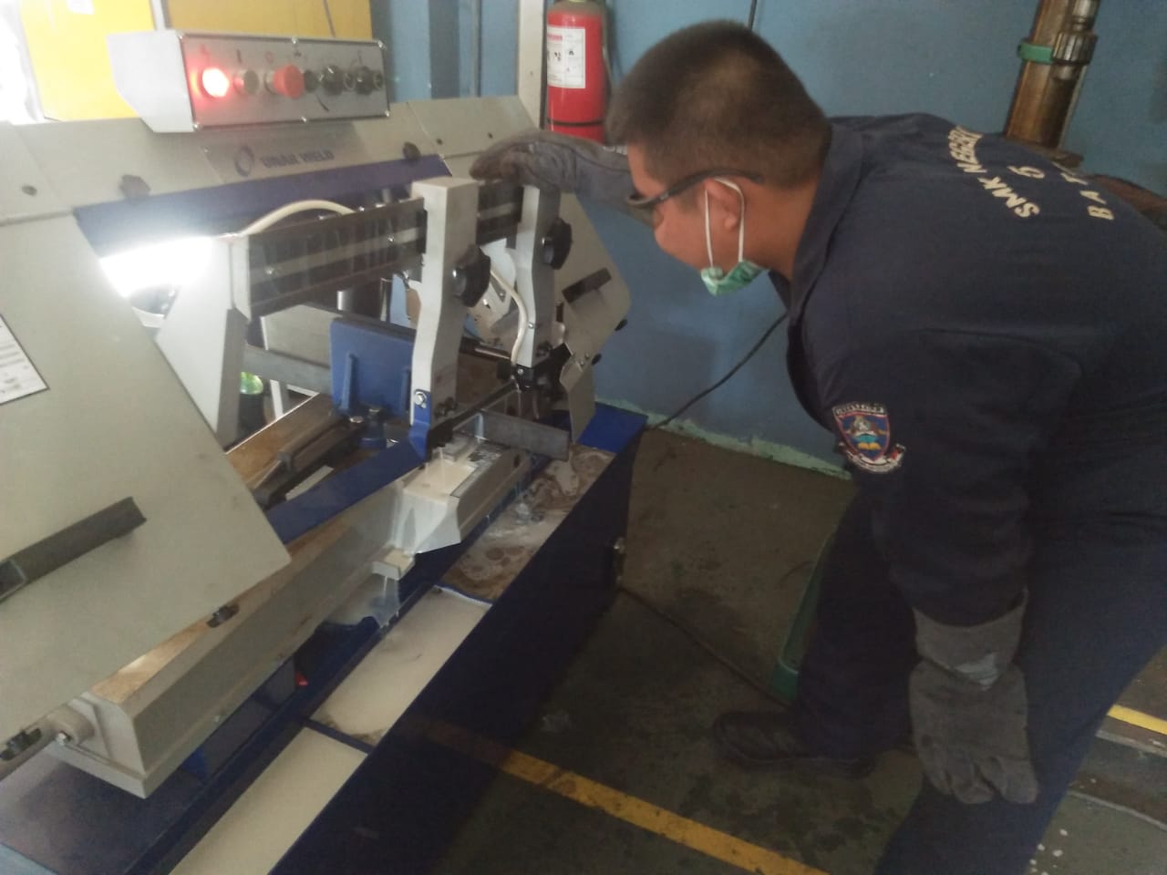 Gambar utama Pemotongan Material Praktek oleh Siswa Dengan Mesin Bandsaw